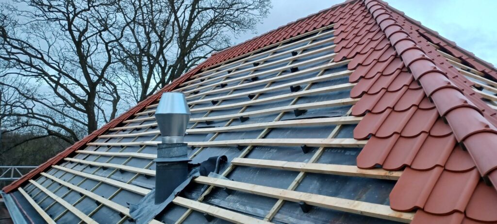 Tagdækning med nye røde tagsten under installation