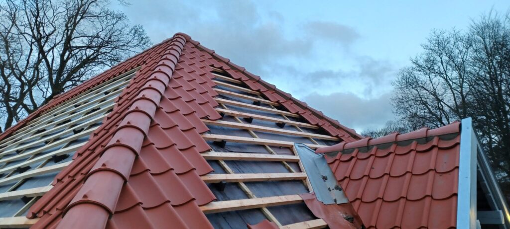 Rødt tegltag under renovering på hus