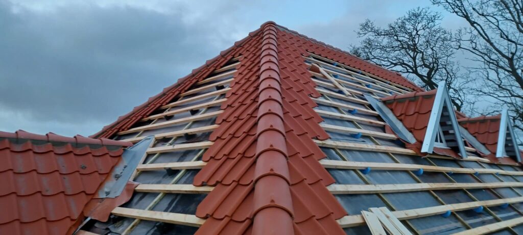 Rødt tegltag under renovering på hus