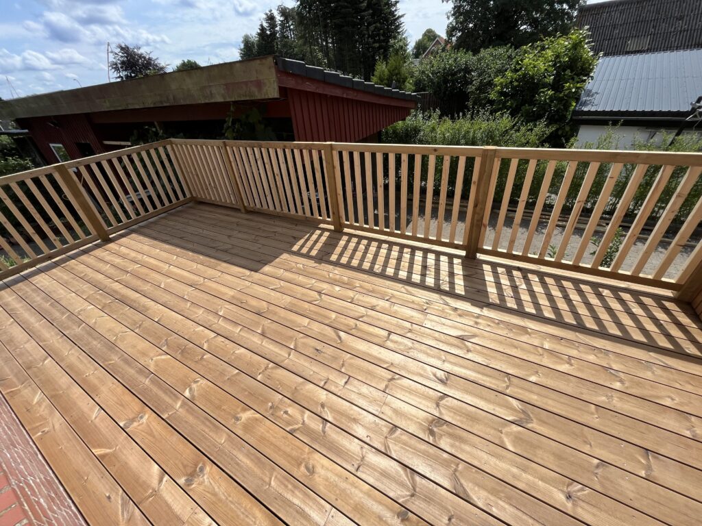 Nybygget træterrasse med gelænder i solskin